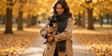 Stylish woman and black tan Chihuahua wearing trench coat matching dog and owner clothes outdoors