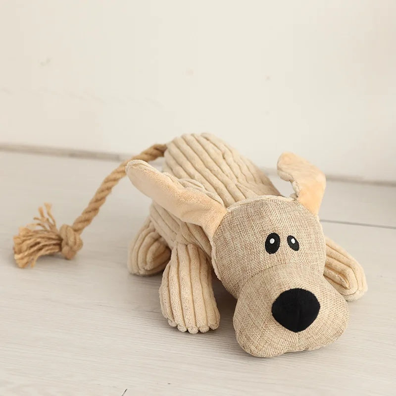 Cute beige corduroy donkey plush dog toy sitting upright on a light wooden floor.