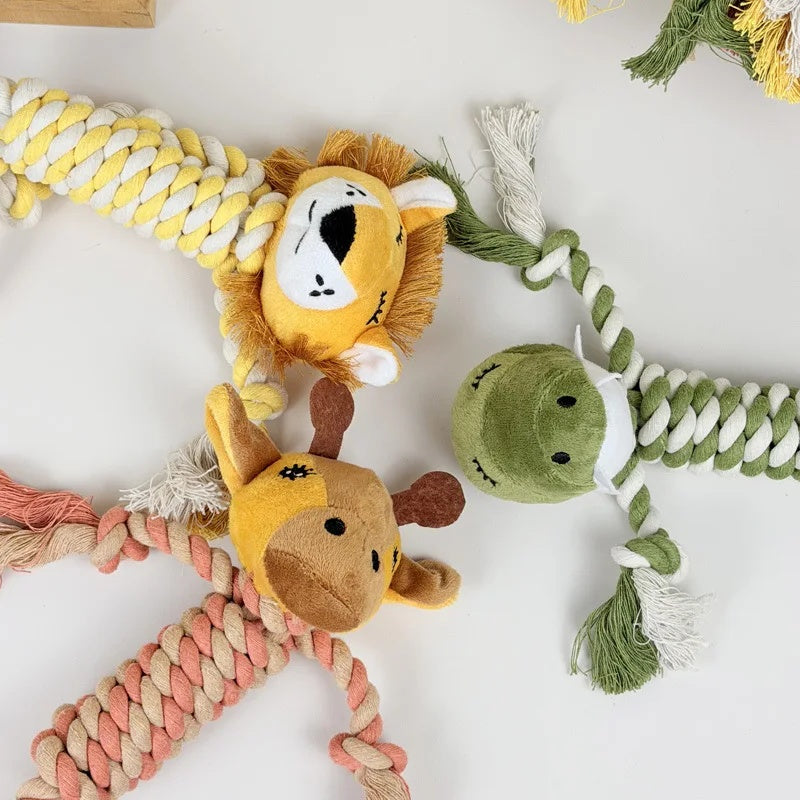 Overhead view of three safari-themed dog rope toys including a lion, giraffe, and crocodile on a clean surface.