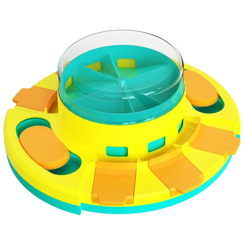 Overhead view of the vibrant yellow, teal, and orange plastic slow feeder puzzle toy for dogs, showing rotating chambers.