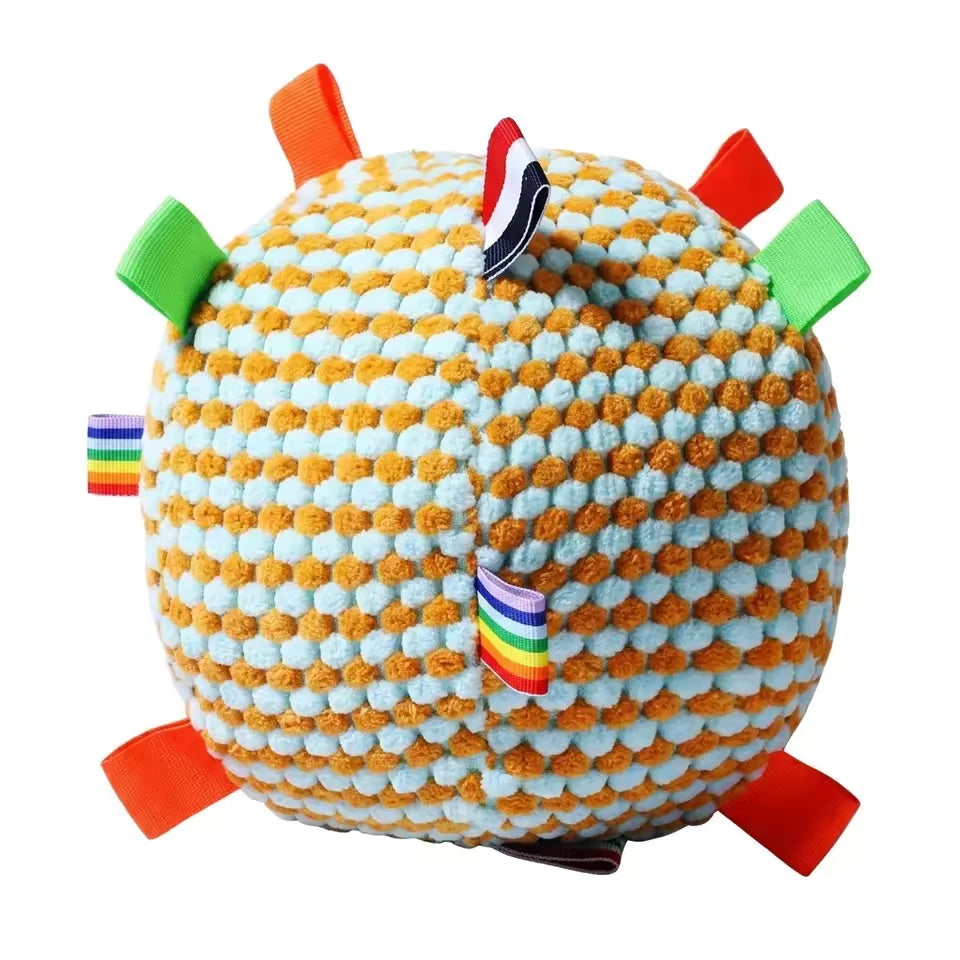 Close-up of the yellow and orange textured fleece squeaky dog ball with colorful grab-tags.
