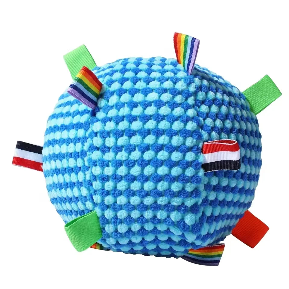 Close-up of the blue textured fleece sensory dog toy ball showing the bumpy fabric and striped ribbon loops.