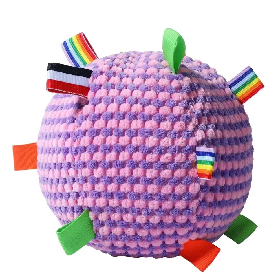 Close-up of the purple and lavender textured fleece sensory pet ball with multi-colored ribbon tags.