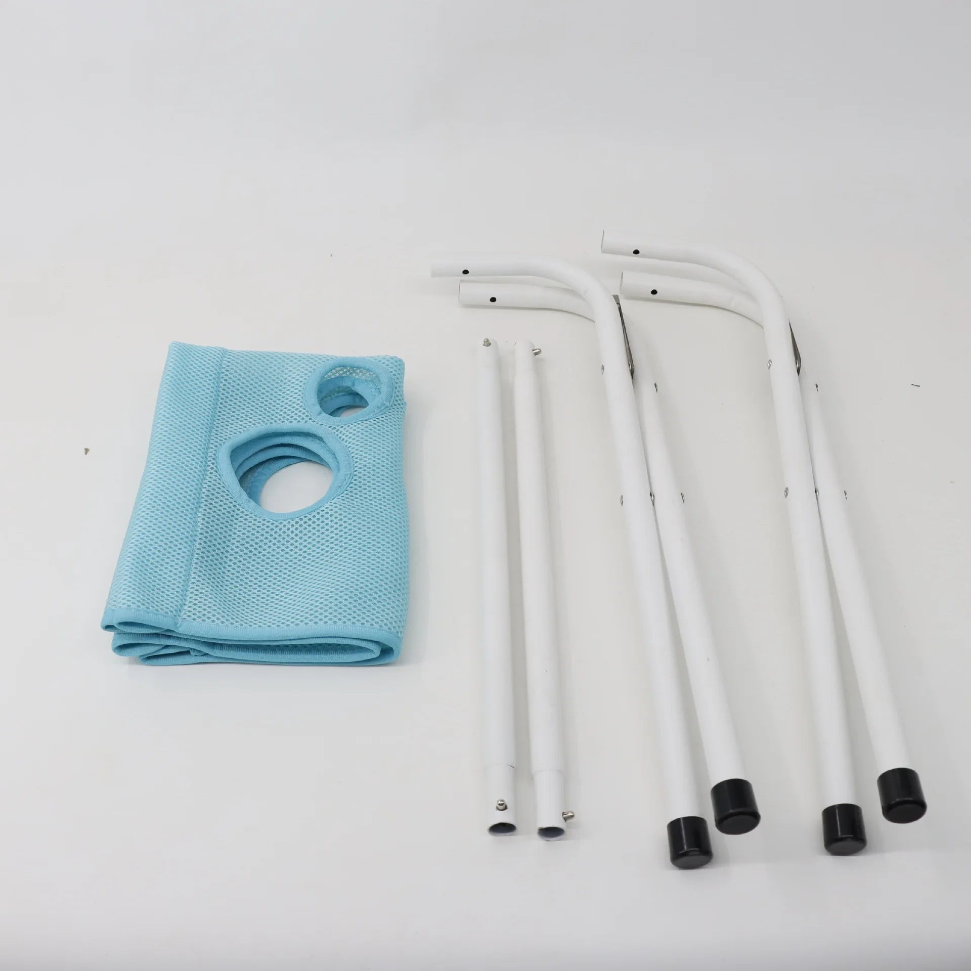 Unassembled components of the pet grooming hammock kit, showing the folded blue mesh and metal frame parts.