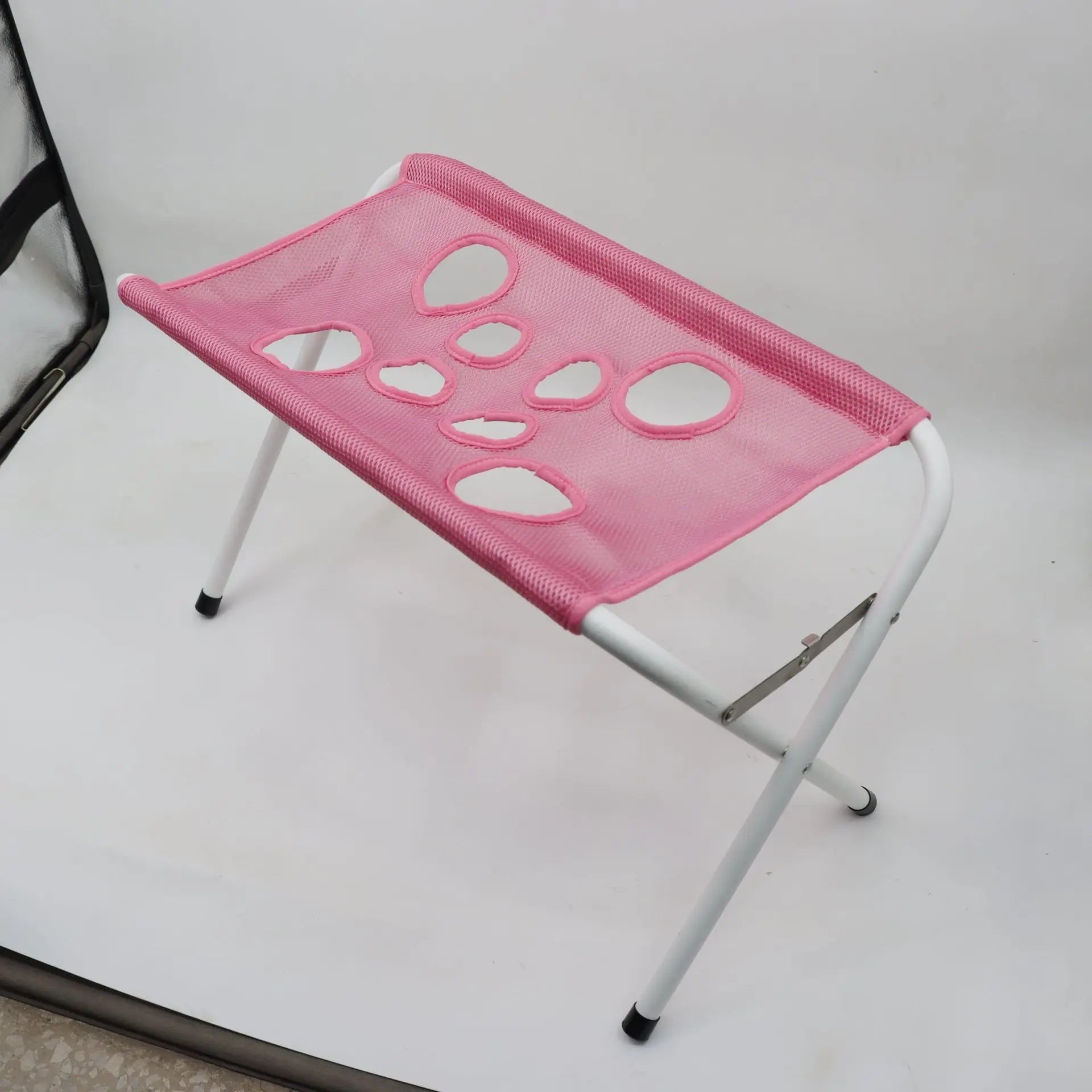 Compact, folded pet grooming stand next to the blue mesh hammock, illustrating easy storage and travel convenience.